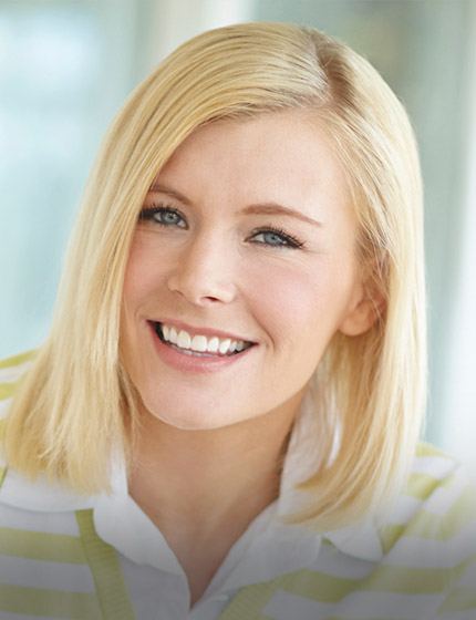 Smiling blonde woman in yellow and white striped shirt