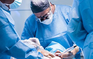 Dentists in blue scrubs performing oral surgery on patient