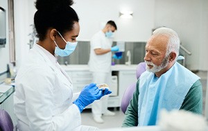 Dentist showing sample dentures to patient