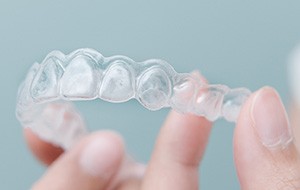 Closeup of patient holding clear aligner