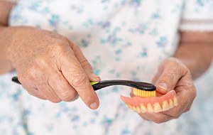 Woman brushing her dentures