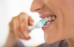 Nose-to-chin profile view of woman brushing teeth