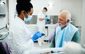 Dentist showing patient model of teeth