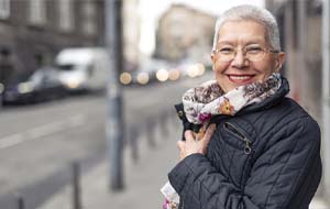 older woman smiling after getting dental implants in Lincoln