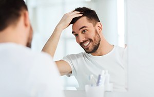 Patient in Lincoln brushing their dental implants