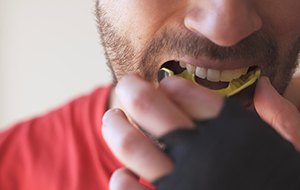 Patient in Lincoln with dental implants wearing a mouthguard