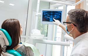 dentist showing a patient X-rays of their mouth