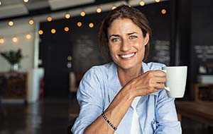smiling woman holding a white mug