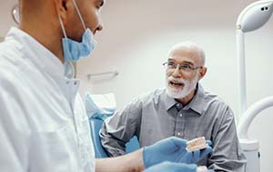 older man asking his dentist questions about dental implants