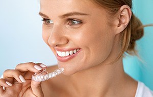 Woman holding Invisalign tray