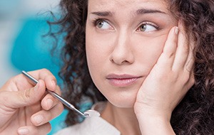 Woman holding jaw in pain needs a root canal