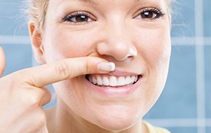 Woman looking at her gums in need fo fullmouth rehabilitlation