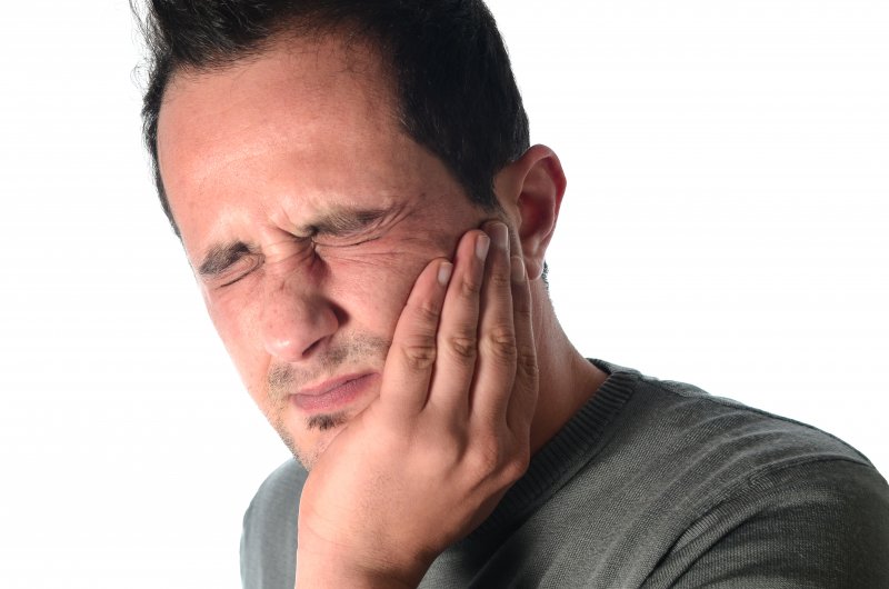 man holding jaw in pain