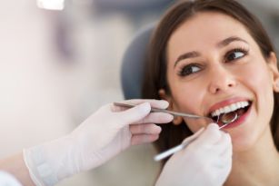 Woman with brown hair having her gums examined by a dentist 