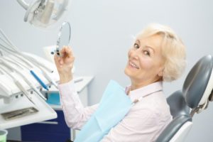 Woman smiles after getting dental implants in Lincoln