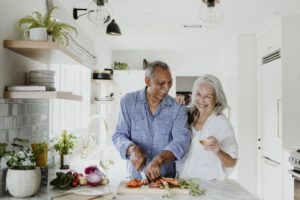 couple with dental implants in Lincoln preparing summer foods 