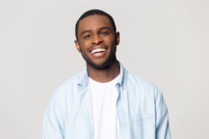 man smiling brightly after seeing his dentist in Lincoln 