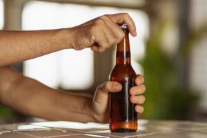 Man’s hands opening a beer