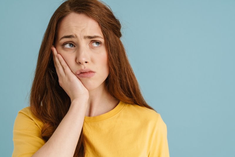 Invisalign patient holding cheek